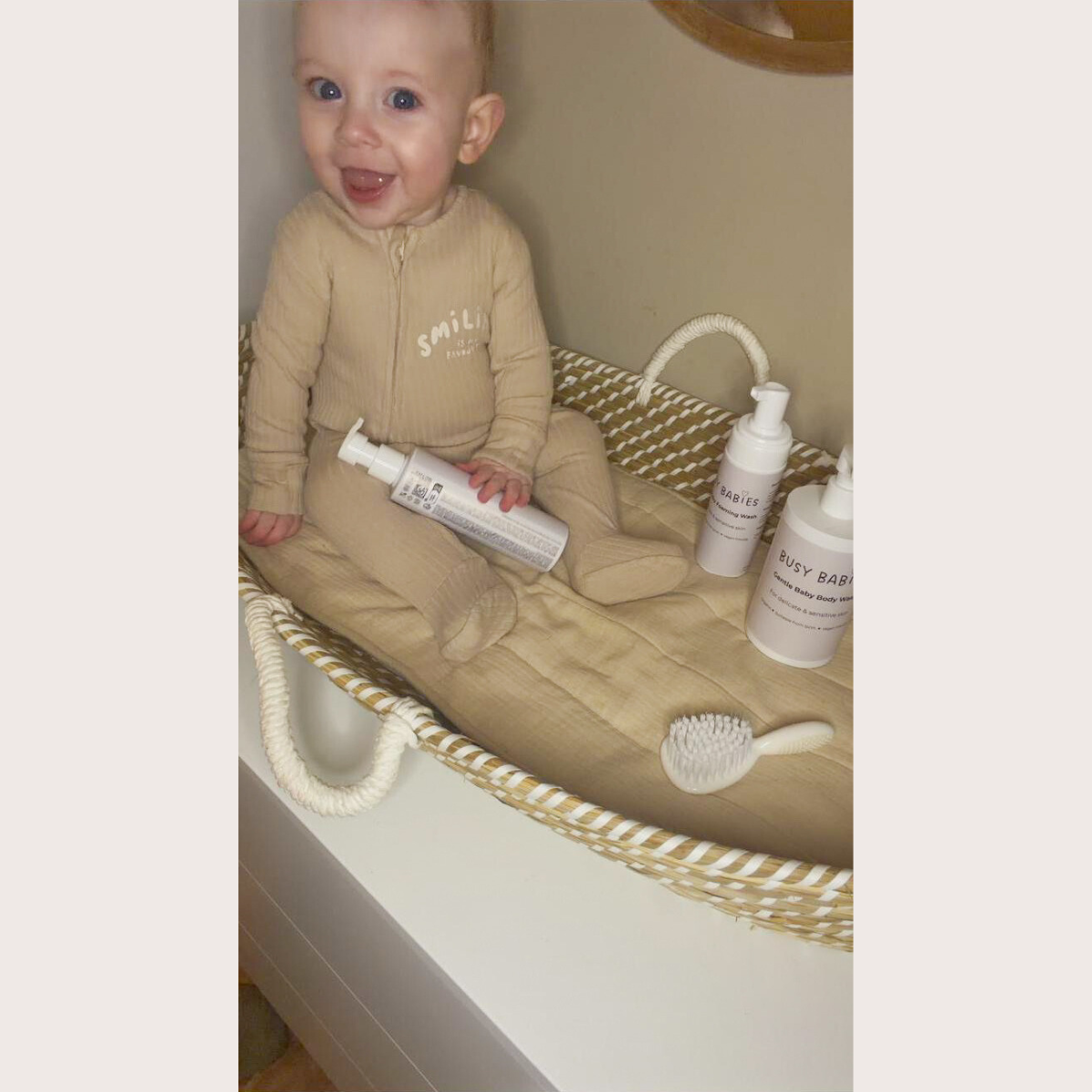 Baby with dry skin sitting beside gentle baby skincare products