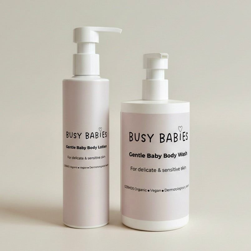 Two bottles of 'Busy Babies' Gentle Baby Body Lotion and Body Wash on a light background