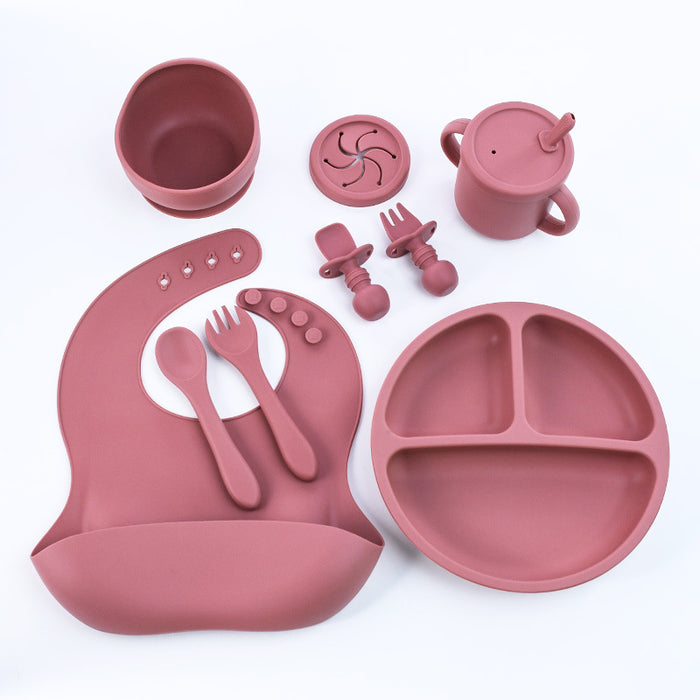 Baby using silicone tableware set with suction plate during self-feeding