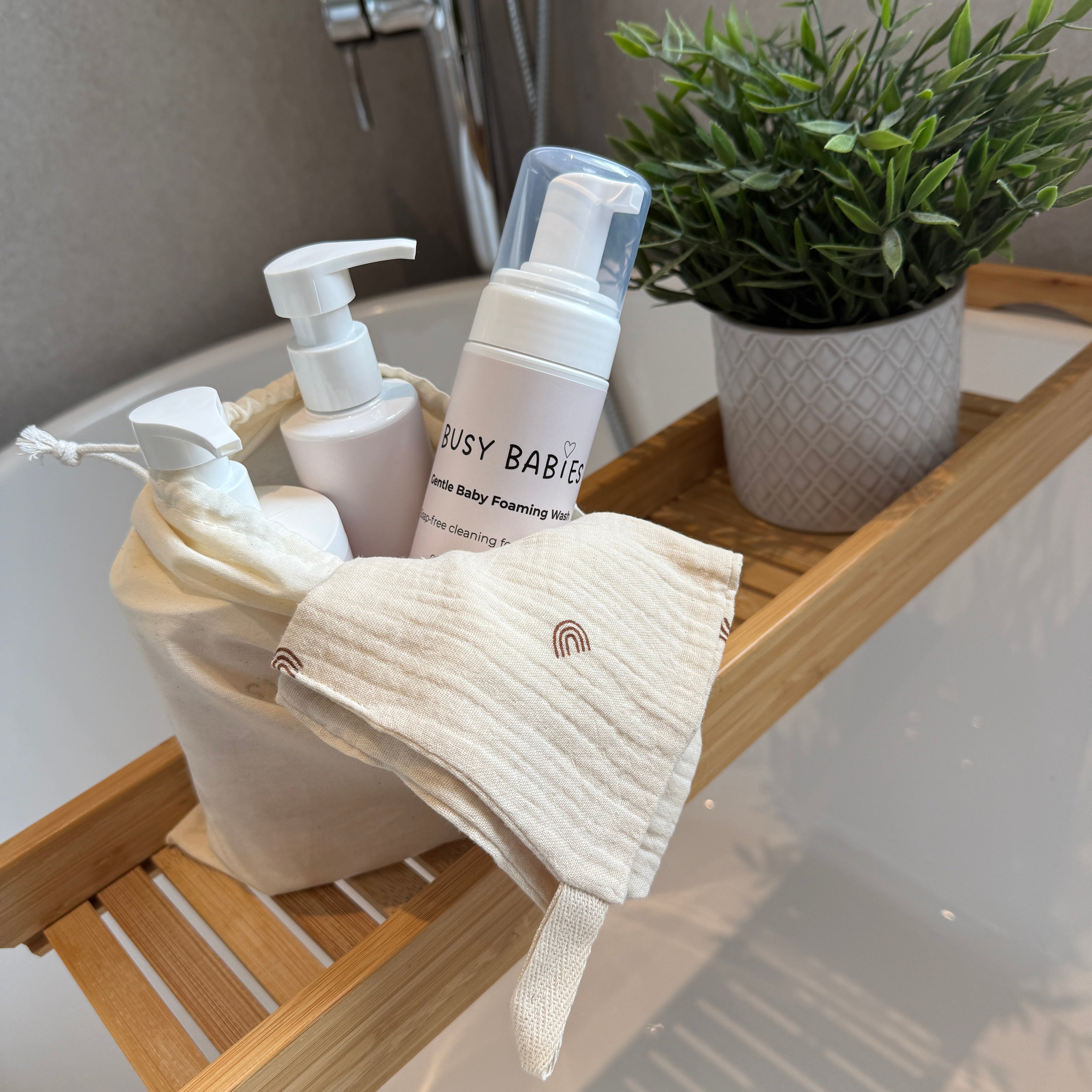 Bathroom shelf with Busy babies bath care products and a plant