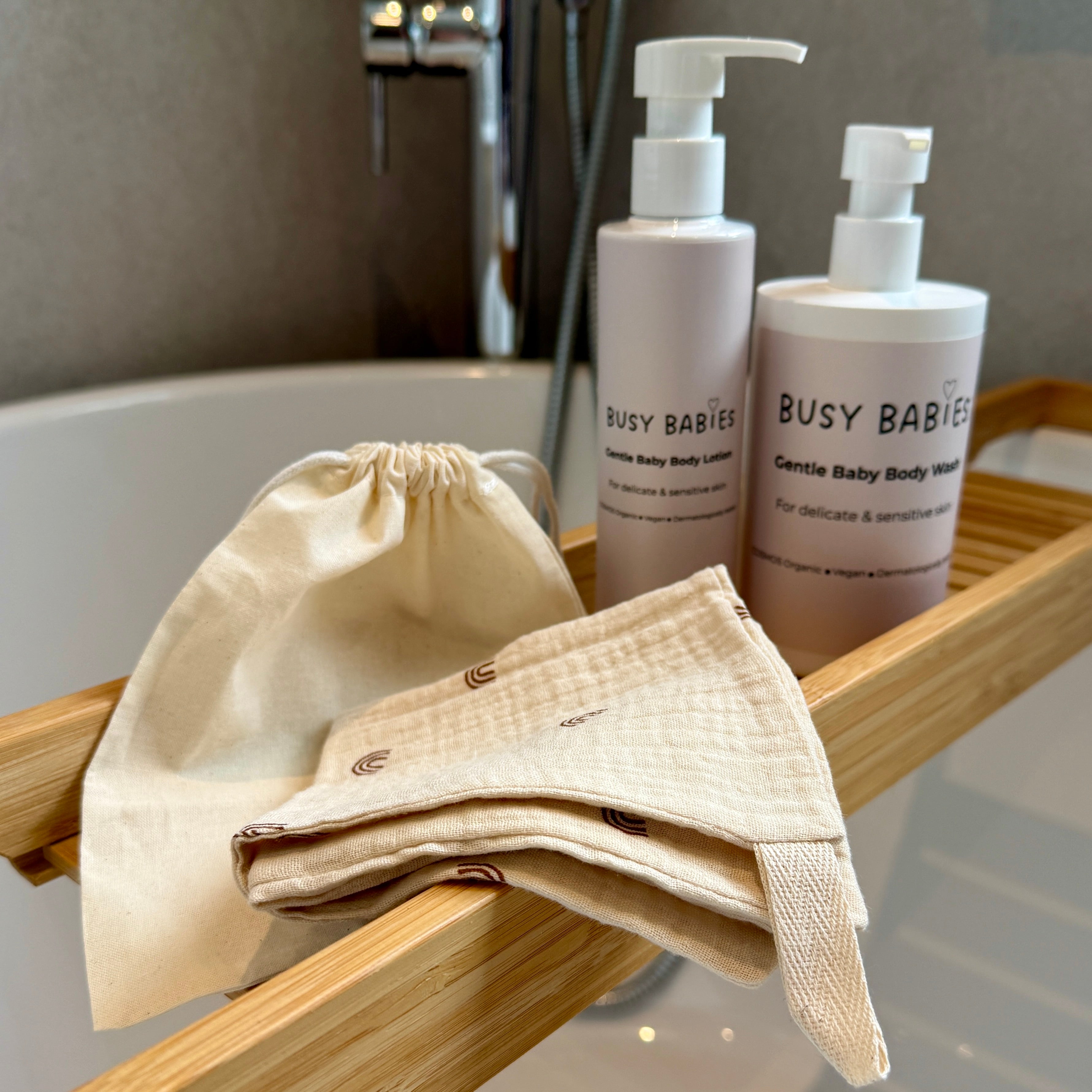 Busy Babies Bath products including a drawstring bag on a wooden tray with a bathroom setting.