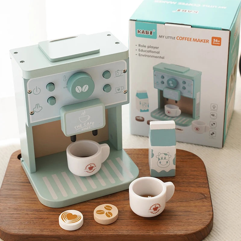 Toy coffee maker set with cups and decorations on a wooden surface, next to its packaging.