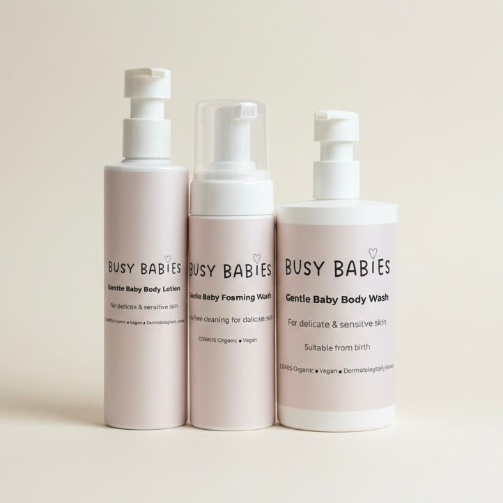 Three bottles of Busy Babies baby care products on a light background